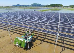 ソーラーシェアリングの設備が設置された水田で行われた田植え作業=2017年5月、秋田県井川町(小型無人機から)