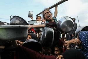 7日、パレスチナ自治区ガザ南部ハンユニスで、食料配給を受けるために集まる人々(ゲッティ=共同)