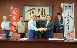 服部勝志消防長(手前左)に乾麺を贈る十日町地域へぎそば組合の小林重則組合長(手前右)=十日町市本町6