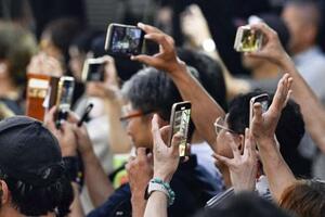 参院選の候補者らの街頭演説をスマートフォンで撮影する人たち=7月19日、札幌市