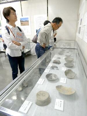 文字が書かれた出土品を鑑賞する来館者=佐渡市新穂歴史民俗資料館