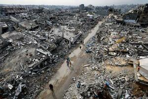 破壊された住宅のがれきの中を歩くパレスチナ人=2025年12月31日、ガザ北部ジャバリヤ(ロイター=共同)