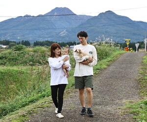 生後3カ月の長男と散歩する髙橋さん夫妻。自宅からは四季折々に表情を変える妙高山が見え、自然豊かな環境で子育てに励む=10月9日、妙高市