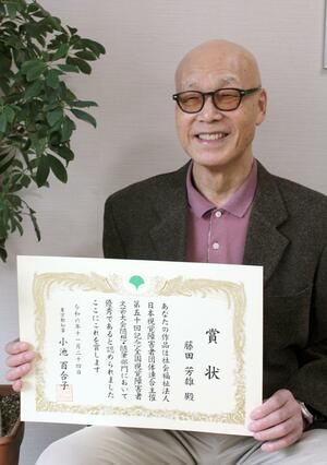 表彰状を手にする藤田芳雄さん=長岡市喜多町