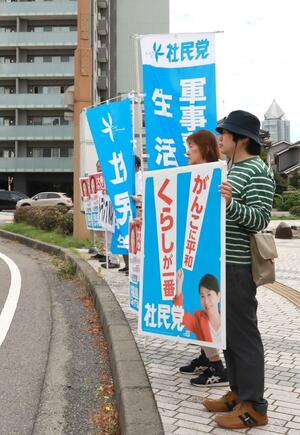 看板やのぼりを掲げ、社民党への支持を訴える党県連の関係者ら=6月25日、新潟市役所前