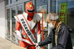特殊詐欺被害防止へ啓発グッズを手渡す燕市のご当地ヒーロー=燕市佐渡