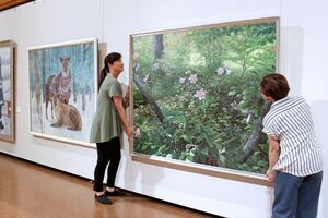 三条美術協会展に向け、絵画の展示作業をする会員=7月4日、三条市荒町2