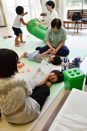 　「宮城こどもホスピスプロジェクト」が間借りした教会の一室で、スタッフと遊ぶ佐藤和さん（手前から２人目）＝７月、仙台市