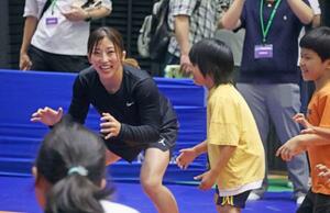 イベントで子どもたちにレスリングを教える須崎優衣(左)=6日、東京都世田谷区の駒沢体育館