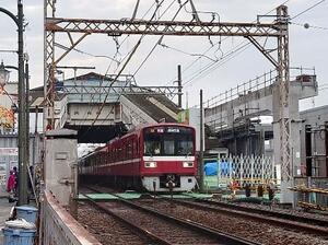 立石駅を通過する下り快速電車。後方に橋上駅舎が見える