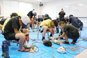 協力して竹あかりの制作に取り組む田上町と成増地区の児童ら=新潟県田上町原ケ崎新田