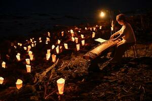 「三船遭難事件」の犠牲者を悼み行われた送り火と演奏=16日夜、北海道留萌市