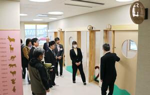 済生会新潟県央基幹病院の隣接地に開設する併設保育施設内を見学する落成式の出席者ら=三条市上須頃