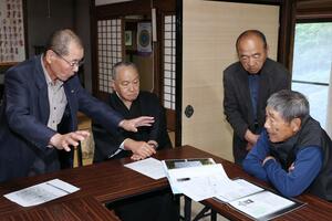 「人頭骨」の新たな鑑定結果を受け、歴史談義に花を咲かせる住民ら=長岡市村田の妙法寺