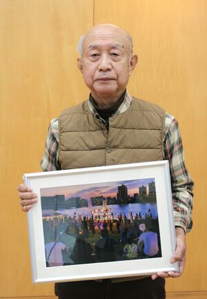 表彰式に出席し、グランプリに選ばれた「川辺の盆踊り」を持つ太田誠二さん=燕市大川津