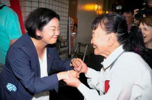 鹿児島選挙区で当選を決め、支持者と握手する尾辻朋実氏(左)=20日夜、鹿児島市