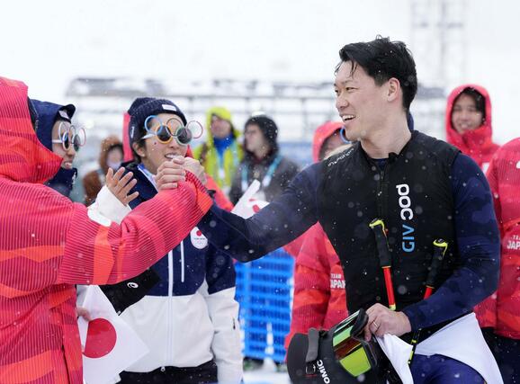 男子スキークロス1回戦で敗退し、関係者にねぎらわれる須貝龍=リビーニョ(共同)