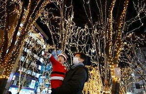 　「ＳＥＮＤＡＩ光のページェント」が始まり、祖父に抱かれ、ケヤキ並木を彩るイルミネーションを楽しむ子ども＝５日夜、仙台市