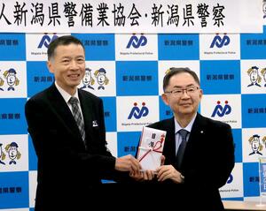 新潟県警備業協会から防犯機能付き電話が贈られた贈呈式=新潟市中央区新光町