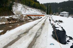 　２０２４年９月の豪雨で被災し、復旧に向けて土のうが積まれた河川の堤防＝１月２８日、石川県輪島市