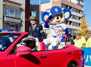 オープンカーでパレードし、集まったファンらに敬礼するドアラ=6日午前、名古屋市