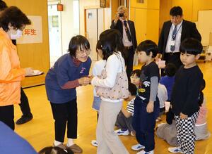 「命のアサガオ」の種を児童に手渡した丹後まみこさん=胎内市江上