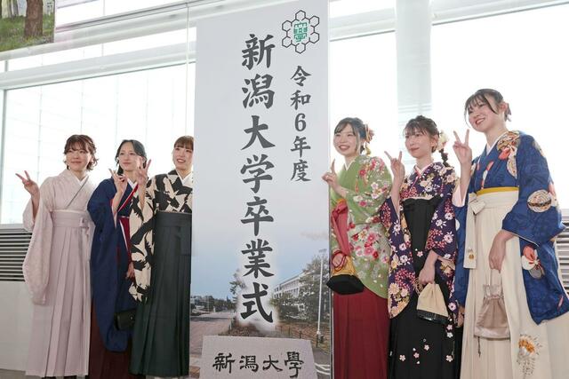 記念撮影する新潟大の卒業生。４月からは、それぞれの道を歩む＝３月２４日、新潟市中央区