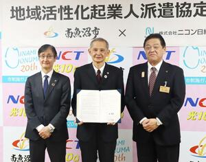 地域活性化起業人として南魚沼市に勤務するニコン日総プライムの小宮山桂さん(中央)=南魚沼市役所