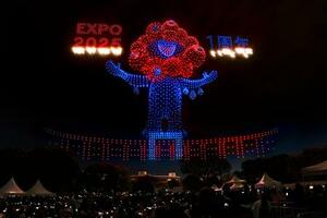 大阪・関西万博開幕1周年記念イベントのドローンショーで、夜空に浮かび上がった「ミャクミャク」=12日夜、大阪府吹田市の万博記念公園