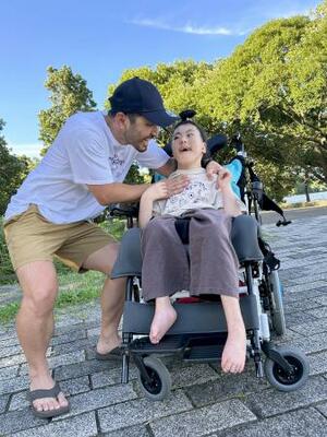 　車いすに乗り公園を散歩する岸本心咲さん（右）と太一さん＝２０２５年７月、東京都葛飾区（太一さん提供）