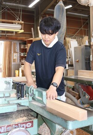 機械で木材を削る熊谷洸希さん。工場内には木の香りが満ちていた=9月19日、新潟市東区木工新町