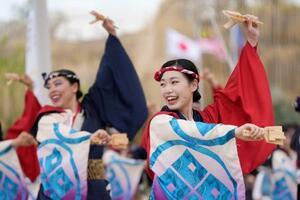 高知県の夏の風物詩「よさこい」を踊るイベントで、演舞を披露する踊り子たち=26日午後、大阪市此花区の夢洲
