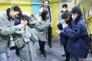 楽しみながら、雪や氷の性質を学ぶ親子連れ=21日、長岡市栖吉町