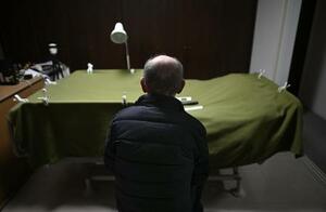 約４０年介護した妻を殺害した部屋で、ベッド脇に座る男性。現在は自身の寝室となっている＝３月、大阪府内