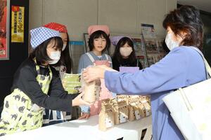 自分たちで育てた「はくて米」を販売する中之口東小の児童たち=新潟市中央区万代1
