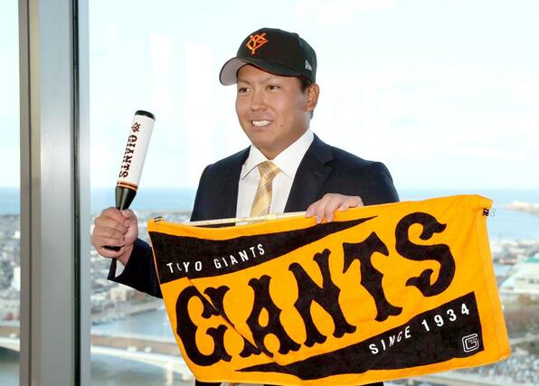 巨人と仮契約を結んだ知念大成。巨人のグッズを手に撮影に応じる=新潟市中央区