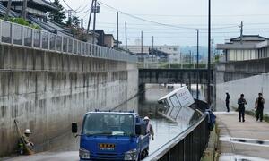 アンダーパスで道路が冠水し、動けなくなった車=18日、新発田市東新町2付近