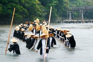 伊勢神宮の式年遷宮に向けて行われた「御樋代木奉曳式」で、神木を綱で引く神宮司庁職員ら=9日午後、三重県伊勢市の五十鈴川