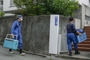 大型冷凍庫から成人男性の遺体が見つかったマンションに出入りする捜査員=22日午前、神戸市中央区