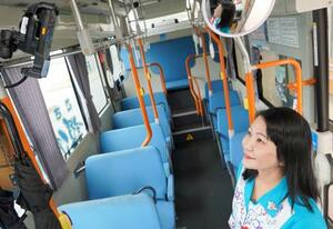 　沖縄県中城村のコミュニティーバスで導入された顔認証システムに顔をかざす比嘉麻乃村長＝１８日午前