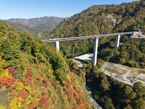 紅葉が彩る八十里越道路の５号橋梁の周辺＝３０日、三条市下田地域（本社小型無人機から撮影）