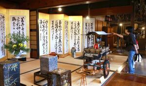町屋に飾られた屛風を観賞する観光客=村上市大町