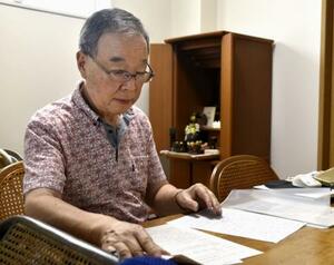 加害者の男に自身の心情を伝えようとつづった書面を見つめる長女を亡くした渡辺保さん=6月、横浜市