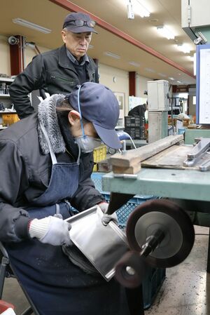 金属製品を研磨する燕市磨き屋一番館の研修生＝燕市小池