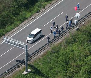 容疑者の男を乗せた車と実況見分をする警察官＝１８日、福島県郡山市（本社ヘリから）