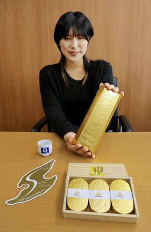佐渡金銀山の世界遺産登録を目指し、新潟商工会議所が作った金塊形ティッシュ(右奥)、小判形入浴剤(右手前)などのオリジナルグッズ=新潟市中央区