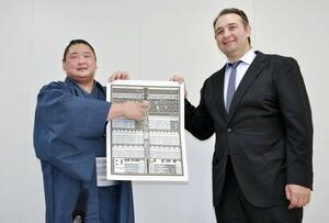 新入幕を果たし番付表を持つ欧勝海。右は鳴戸親方=27日、佐賀県唐津市
