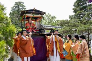 色鮮やかな平安装束姿で出発する、葵祭のヒロイン「斎王代」の塩見真桜さん=15日午前、京都市