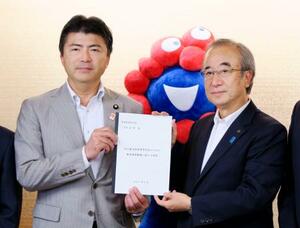 洋上風力発電に関する要望書を古賀友一郎経産副大臣(左)に手渡す花角英世新潟県知事=16日午後、経産省