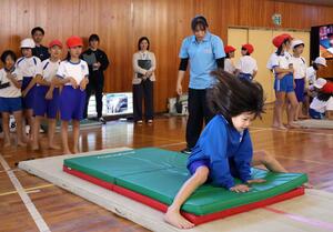 体操女子元日本代表の大島杏子さんが児童にマット運動を教えた出前授業＝上越市飯